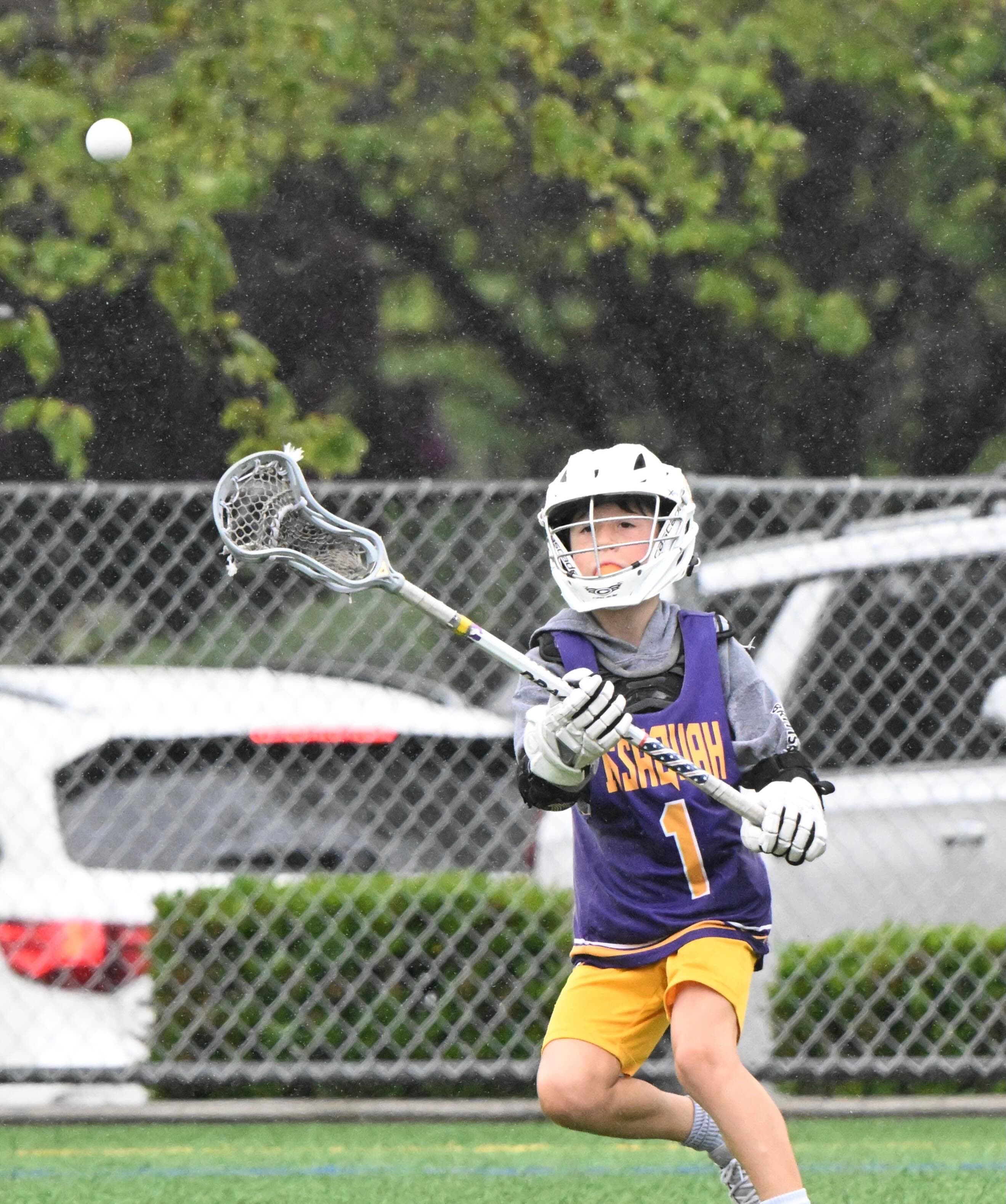 An Issaquah 5/6 player watching the ball with his stick raised.